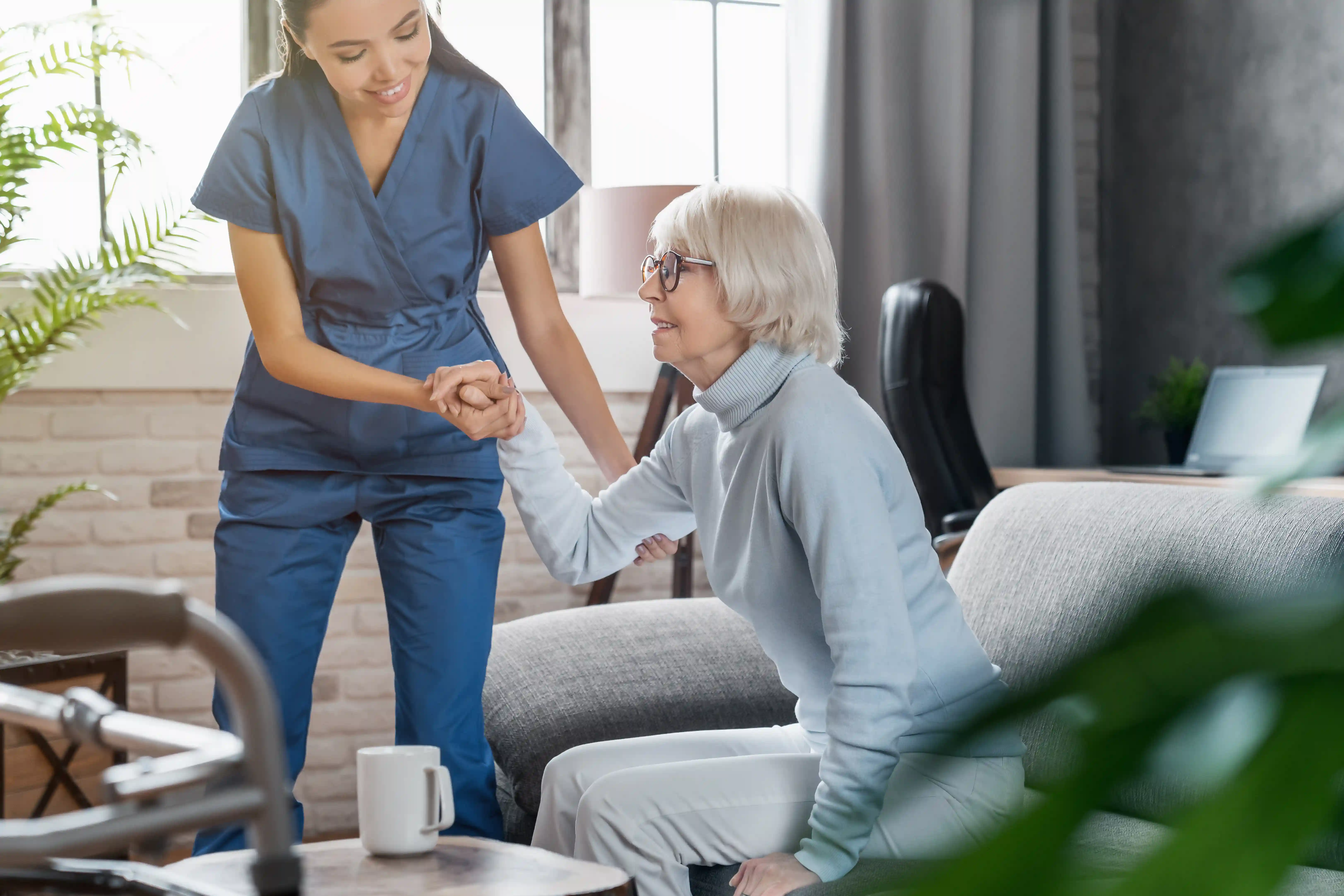 Professional caregiver supporting an elderly resident in a group home setting